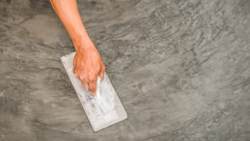 personne en train d'étaler du béton ciré